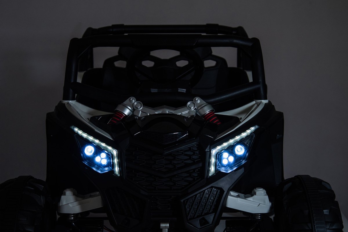 The UTV's blue-white LED headlights glowing in the dark