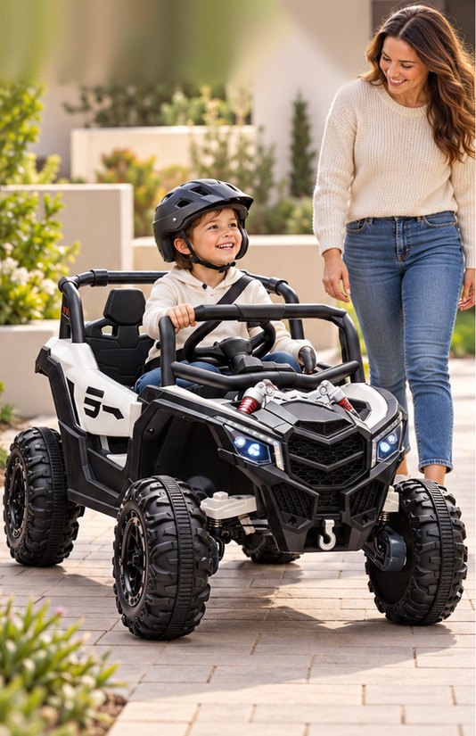 A boy drives the UTV along a paved walkway while his mom walks beside him