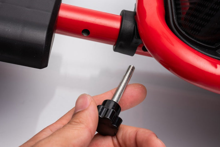 A hand holds the locking knob next to the adjustment holes in the frame